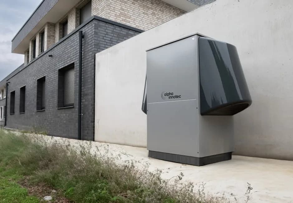 Heat pump outdoor unit running in winter beside an Ontario home