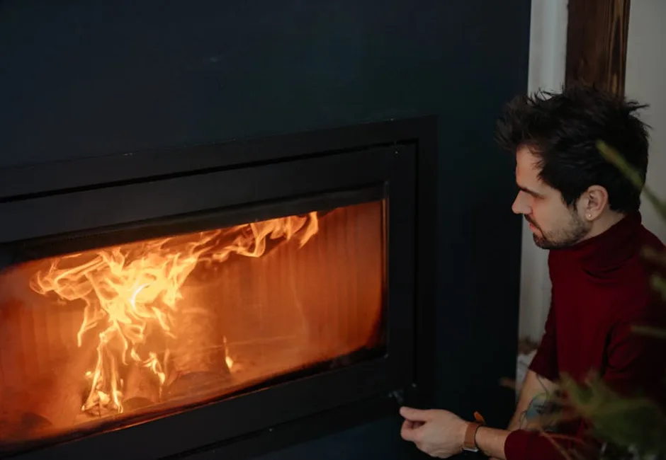 Person relaxing by a warm fireplace in a cozy home