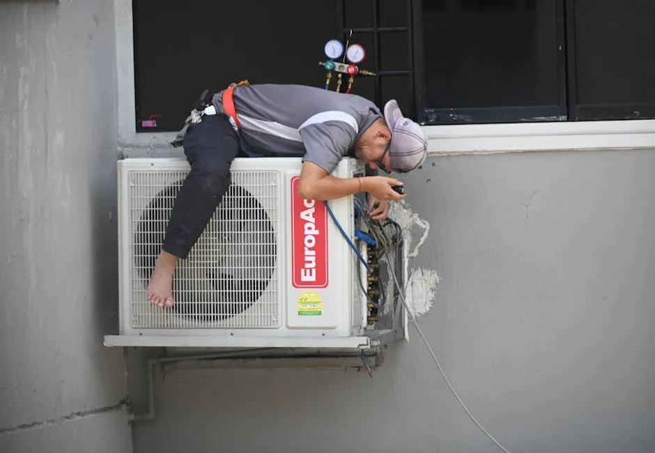 HVAC technician repairing an outdoor air conditioning unit at a residential home