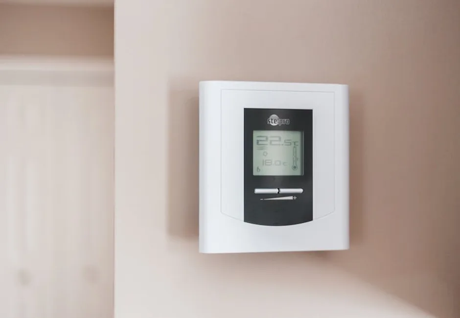 Digital thermostat on a wall showing temperature settings for a home heating system